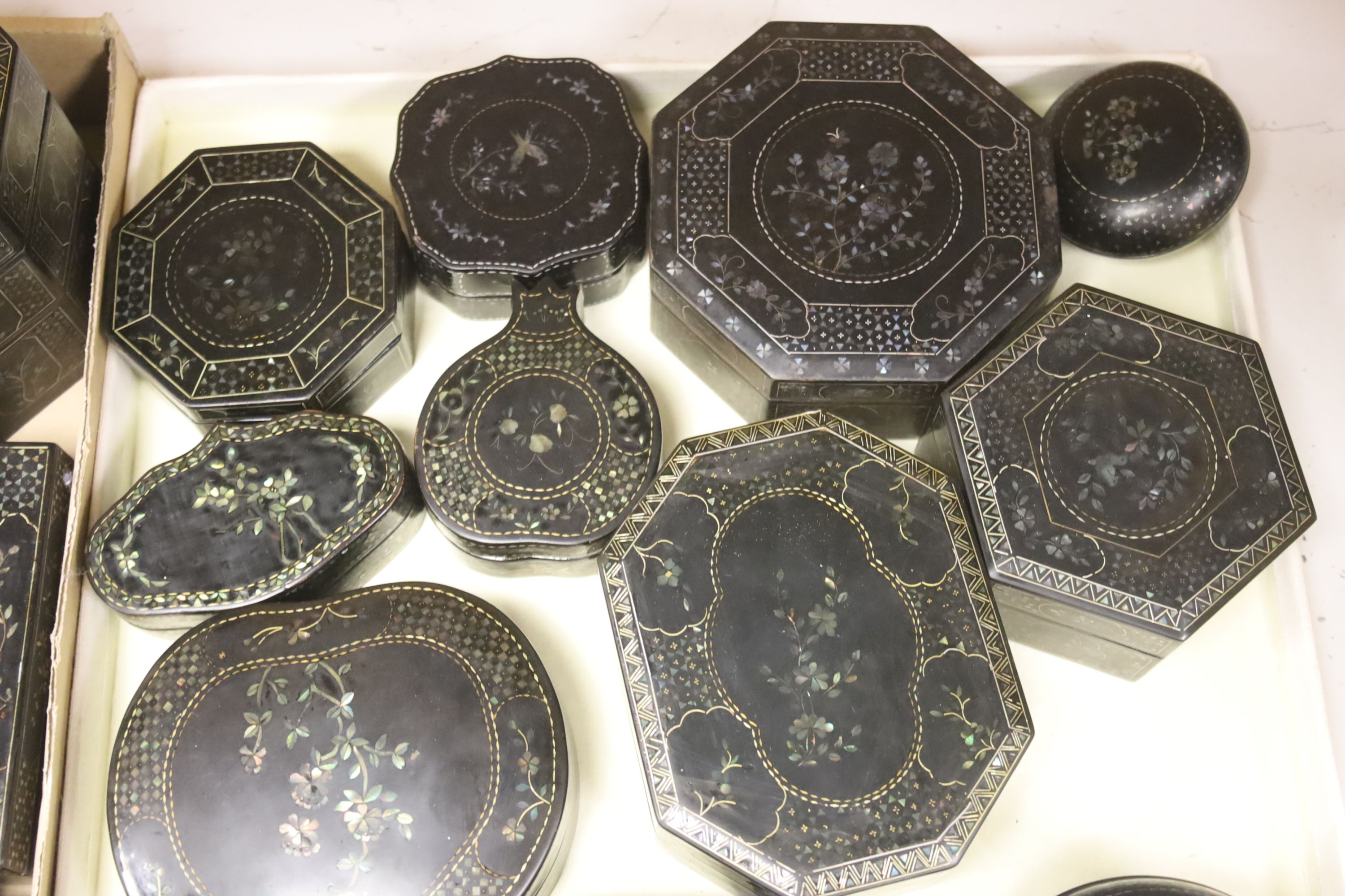 A quantity of Lac Burgaute boxes, inlaid with mother of pearl, largest 13cm diameter 10cm high (26)